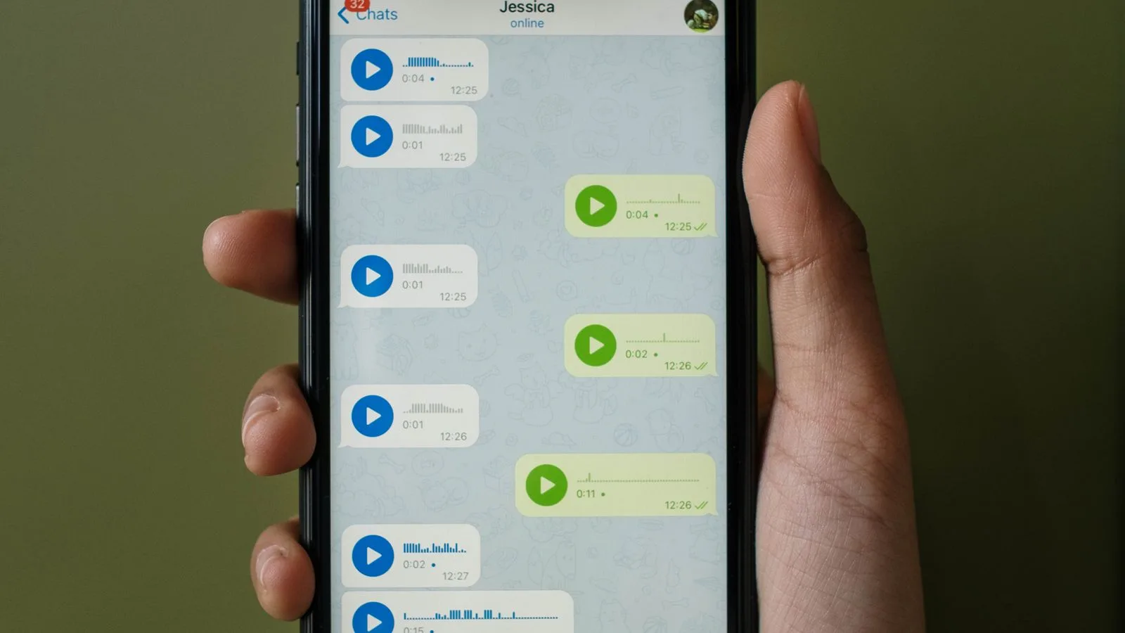 A hand holding a phone with a messaging screen: wholesale selling over WhatsApp
