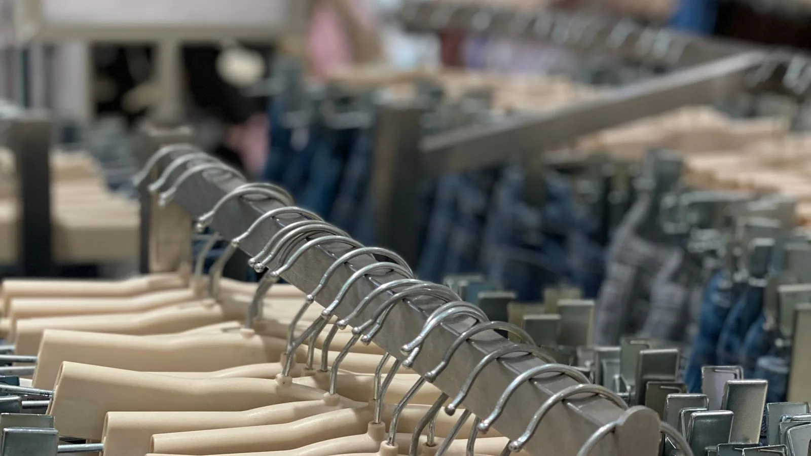 Rows of hanging garments in a wholesale clothing warehouse