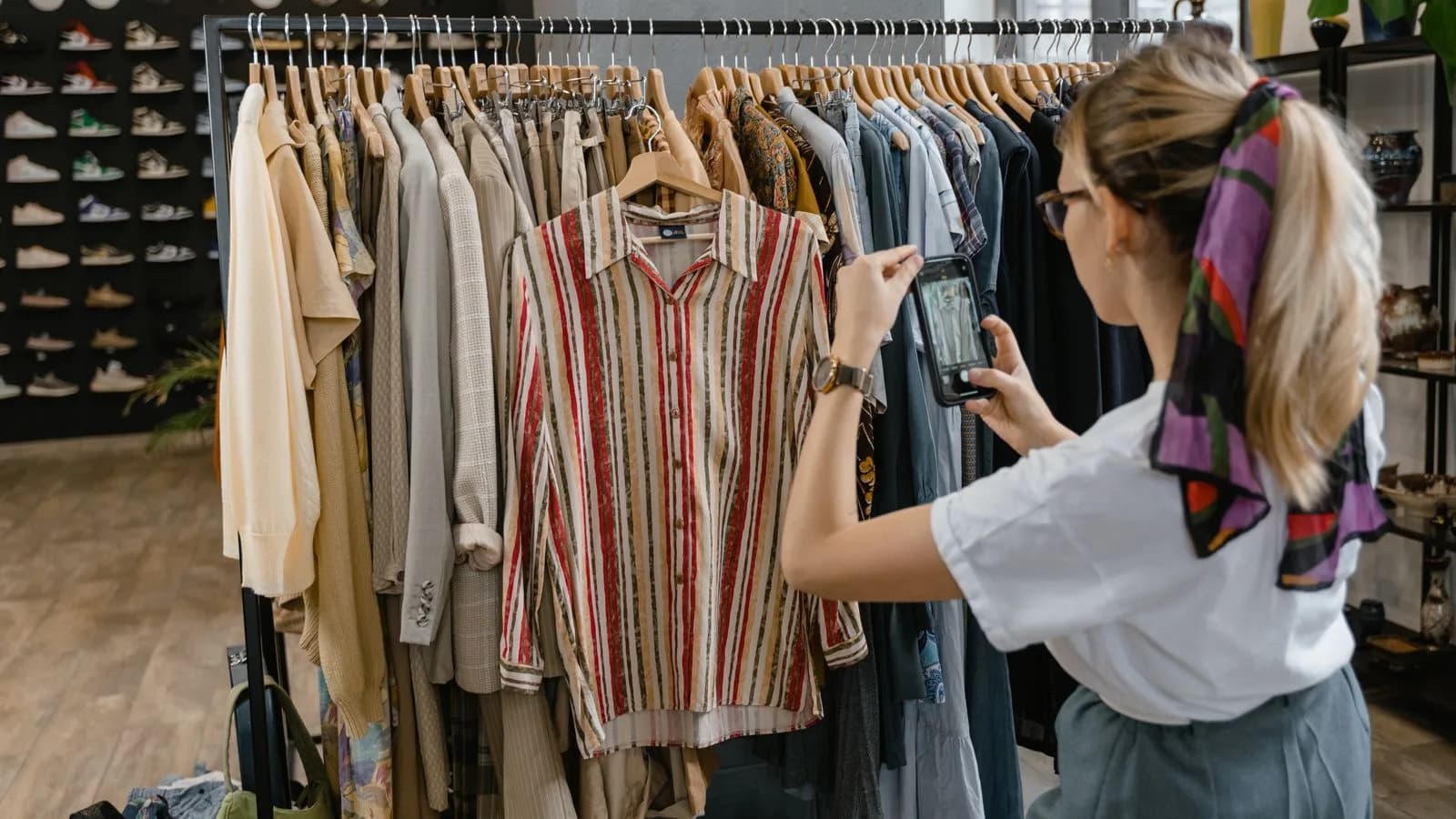Woman photographing clothes on a line at home with a smartphone